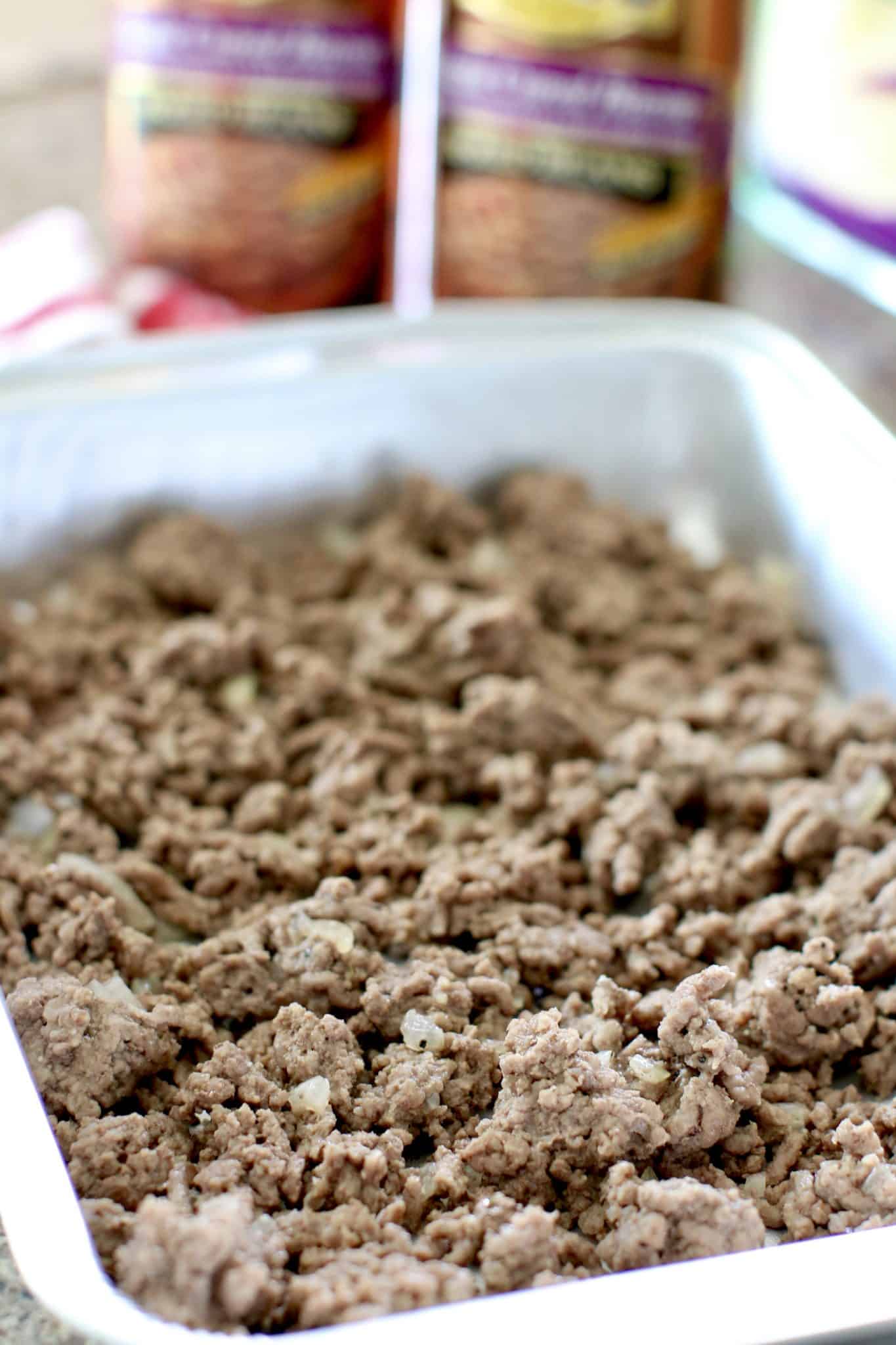 cooked ground beef layered in a baking dish.