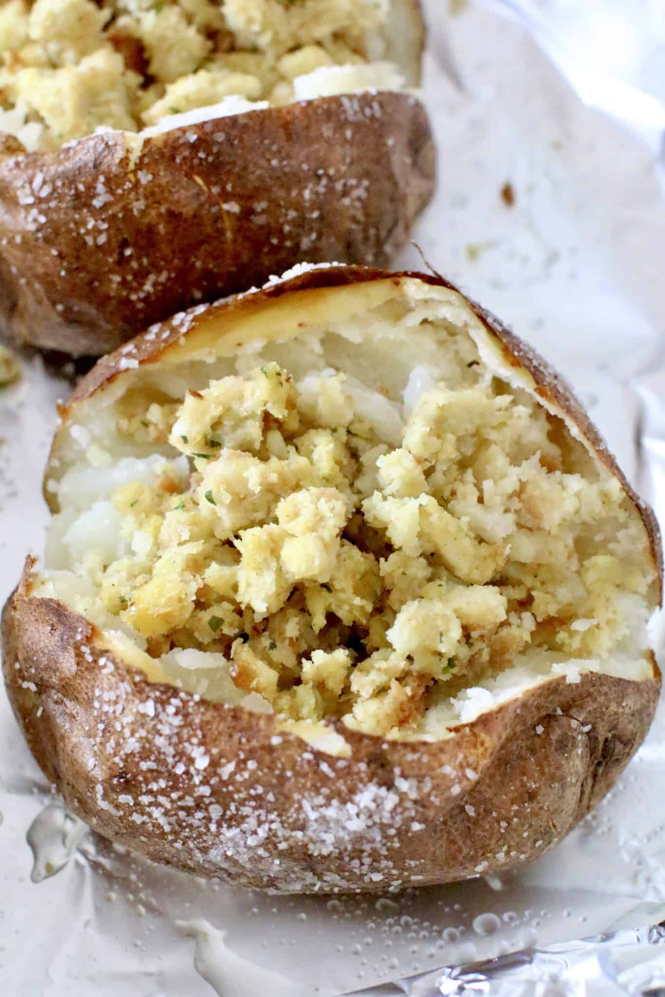 adding stuffing into fully cooked baked potatoes.