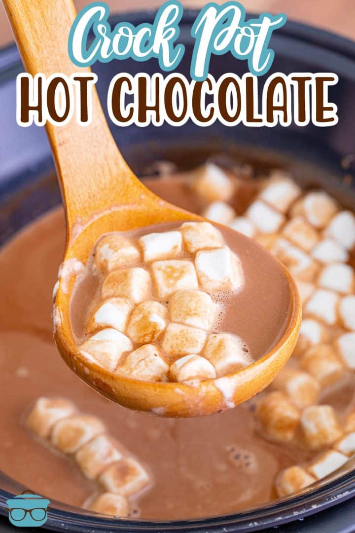 a wooden ladle scooping up some hot chocolate from a slow cooker. 