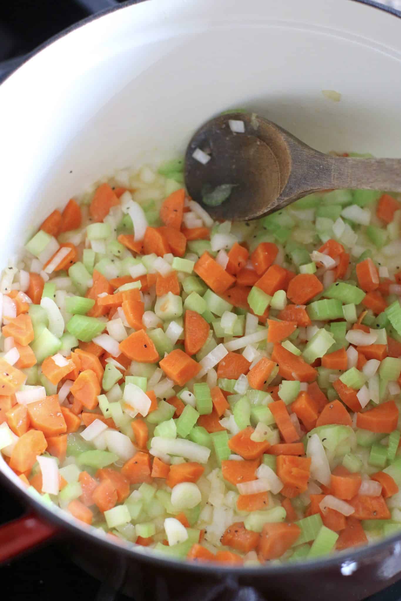 diced celery, carrots and onions in the bottom of a dutch oven with a wooden spoon string it together. 