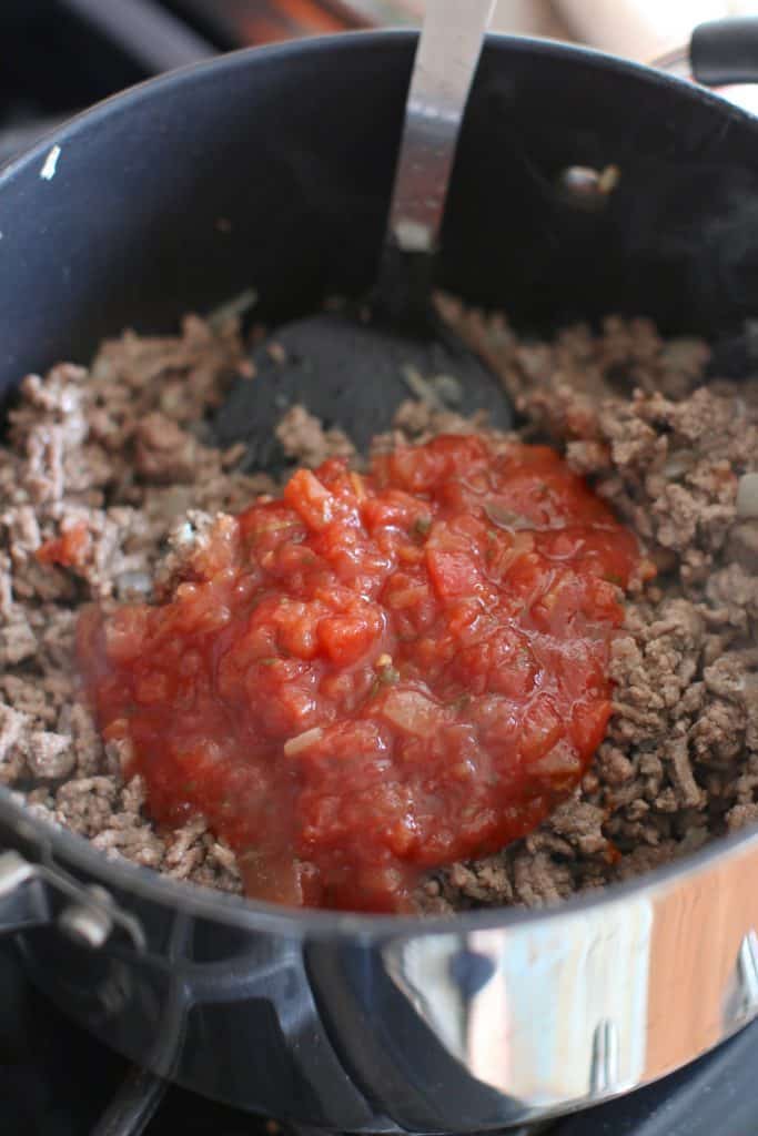 salsa added to cooked ground beef in a skillet.