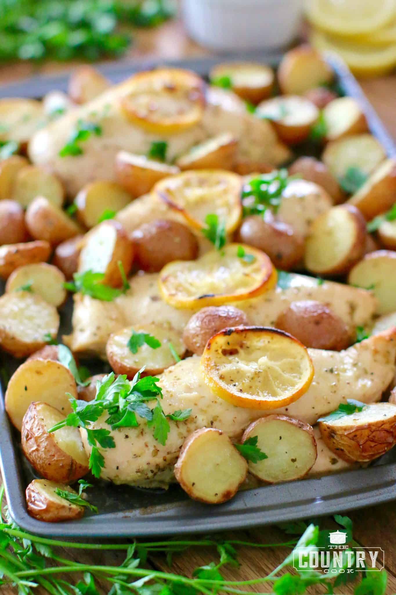 One Pan Greek Lemon Chicken and Potatoes shown fully cooked and on a baking sheet.