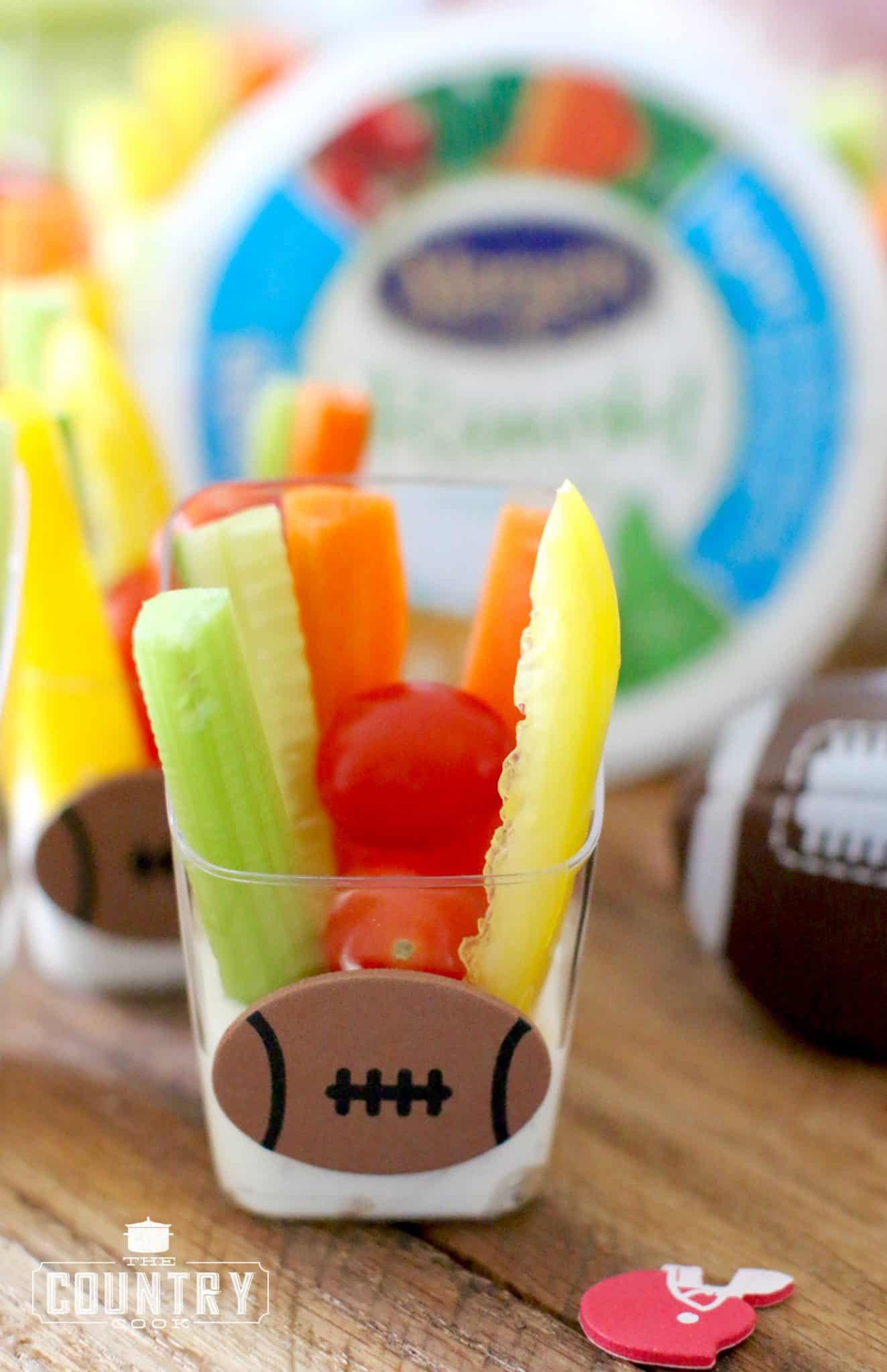 closeup photo of one of the veggie dip cups with a football sticker on it. 