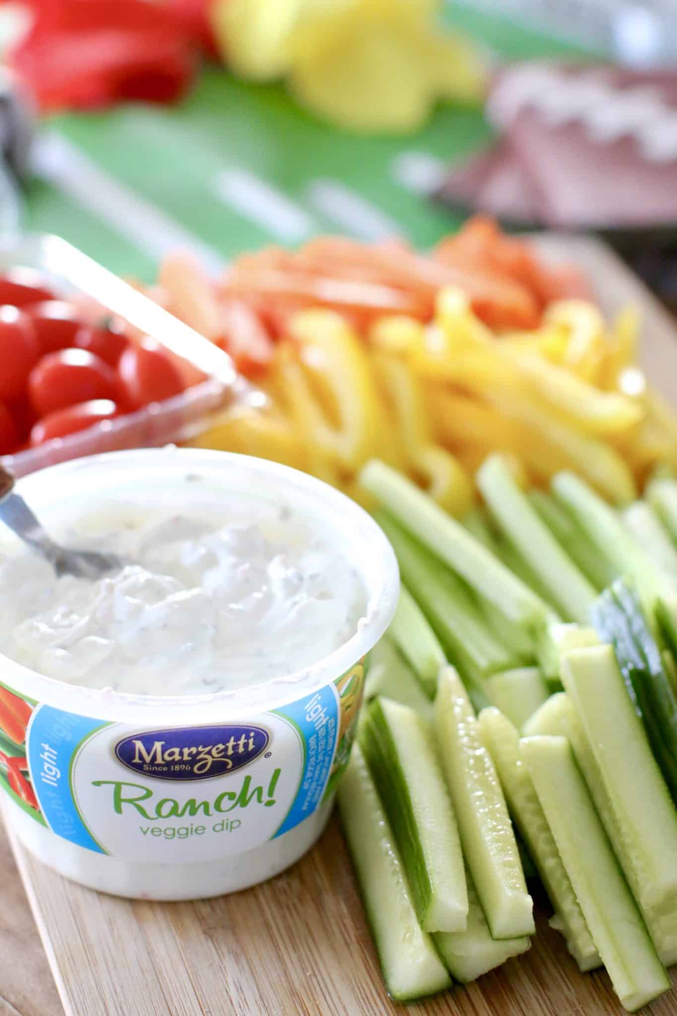 sliced vegetables on a try with a tub of ranch dip on the side. 