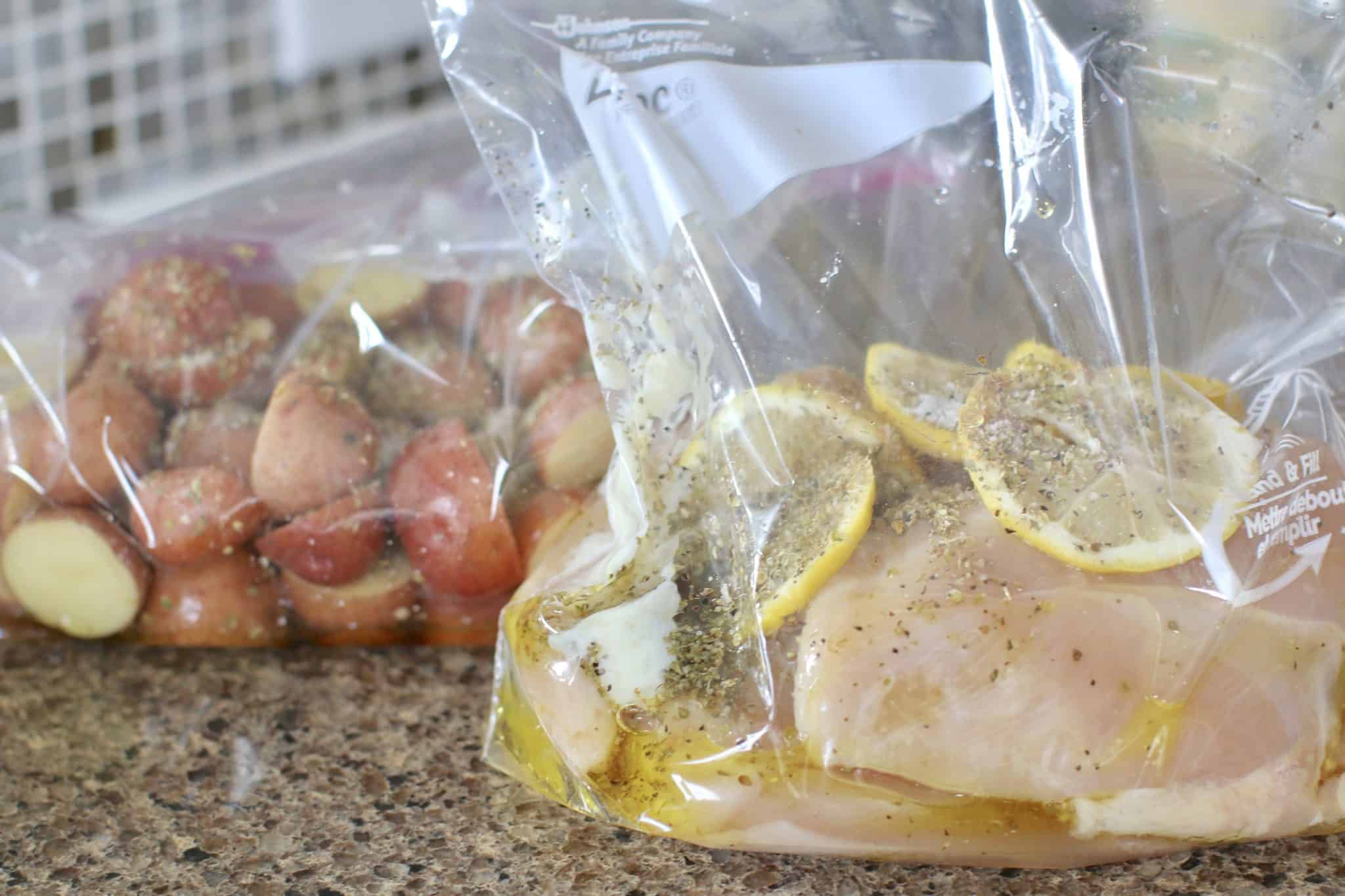 marinade added to both bags holding chicken breasts and sliced red potatoes.