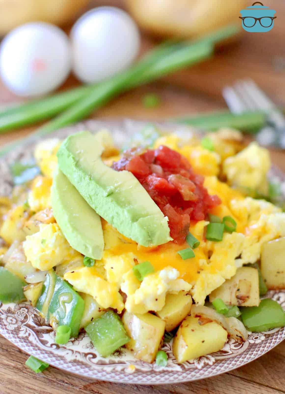 roasted diced potatoes with peppers and onions topped with scrambled eggs, melted cheese, avocado and salsa. 