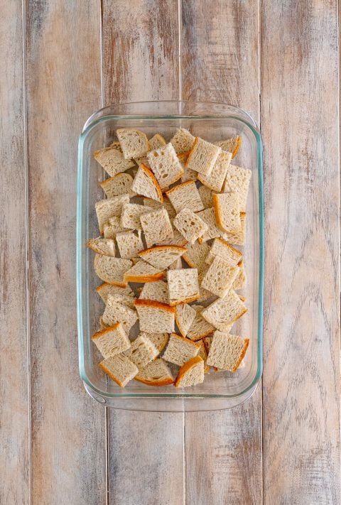 A baking dish filled with bread cubes.