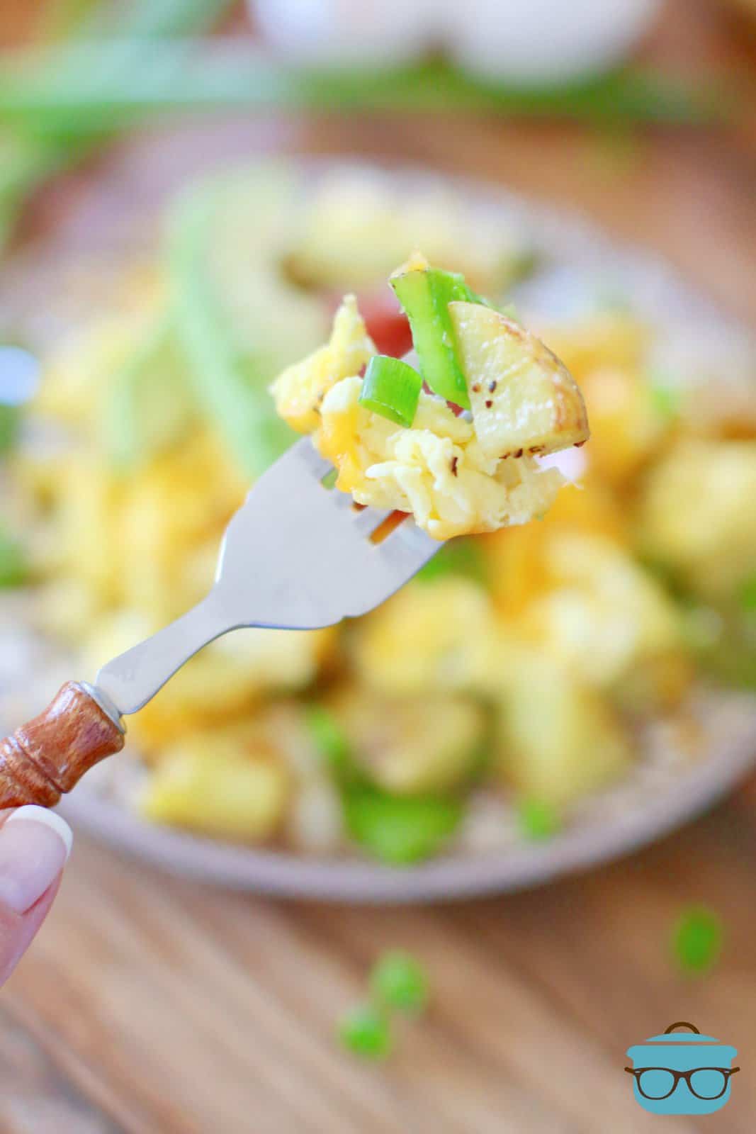 a fork holding up a serving of potato, pepper and eggs. 