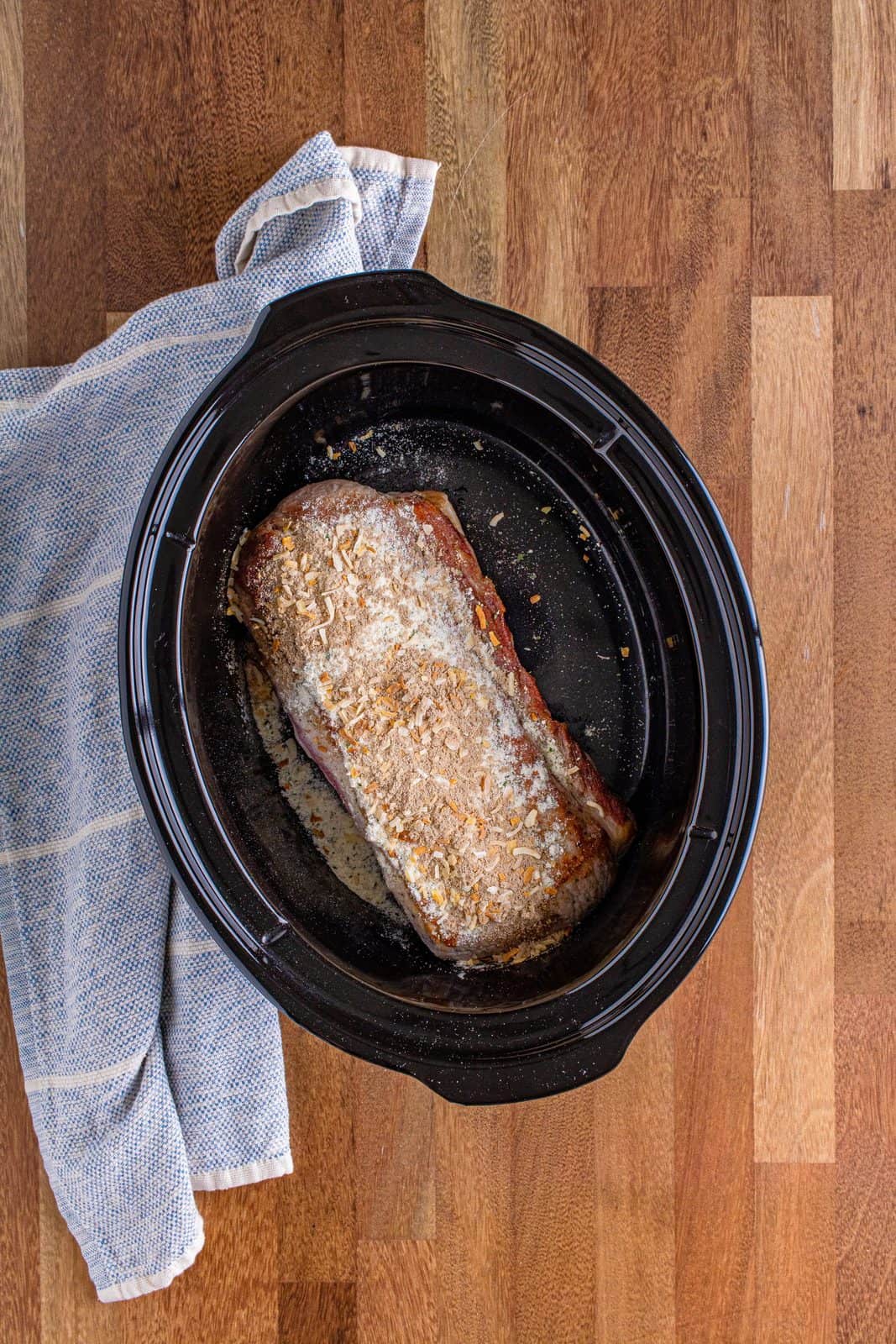 ranch dressing seasoning and French onion soup mix sprinkled evenly on top of pork roast in the slow cooker.