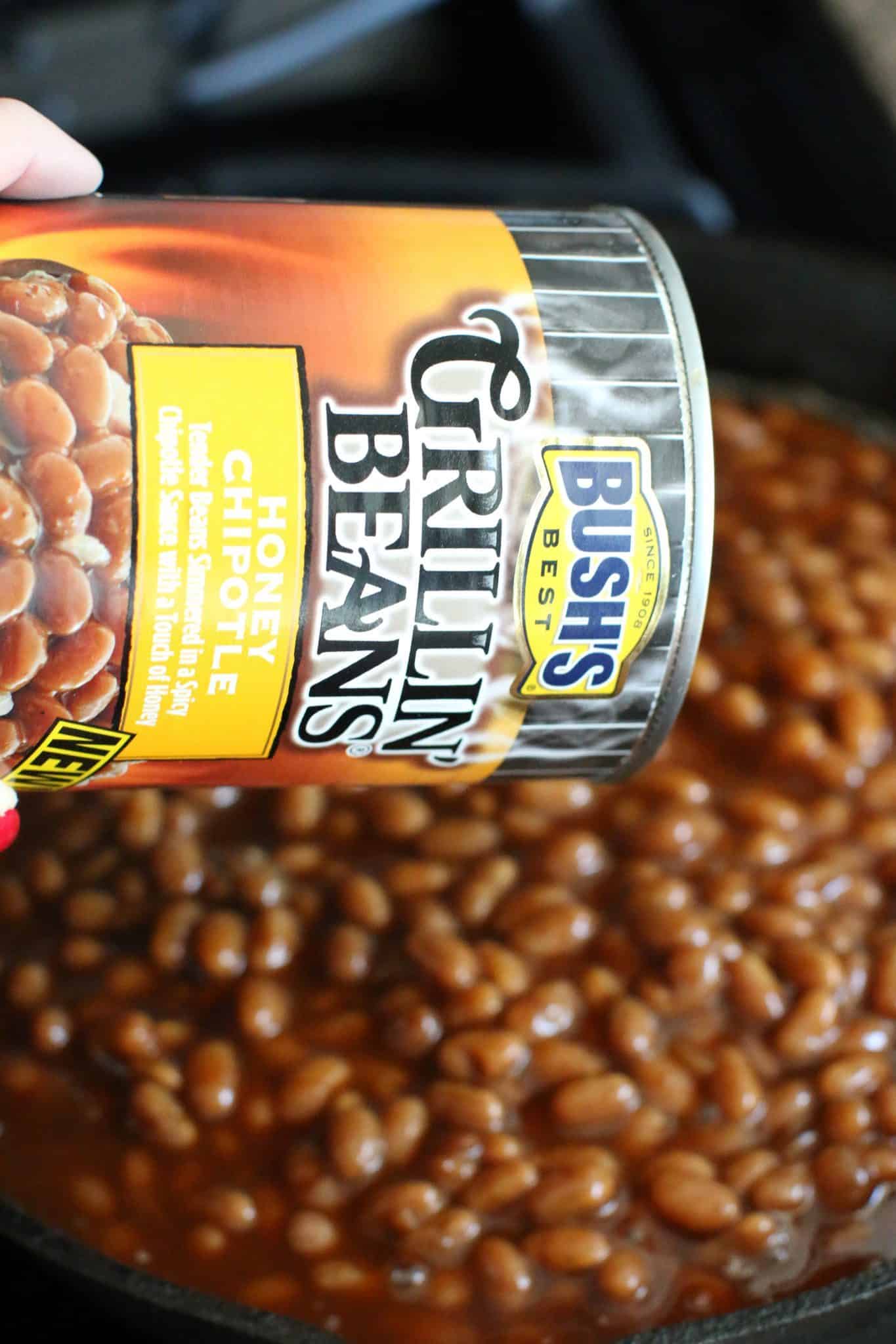 pouring a can of beans into a skillet.