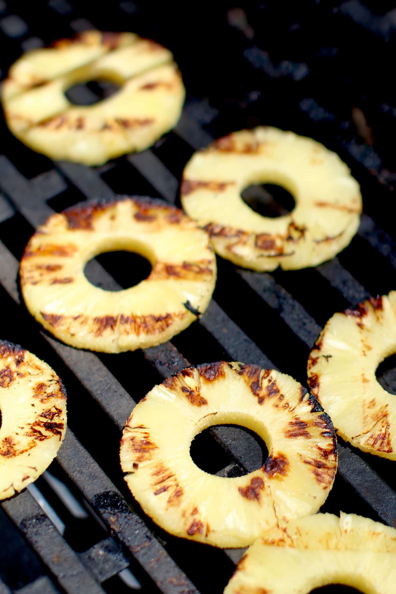 slices of pineapple shown being grilled.