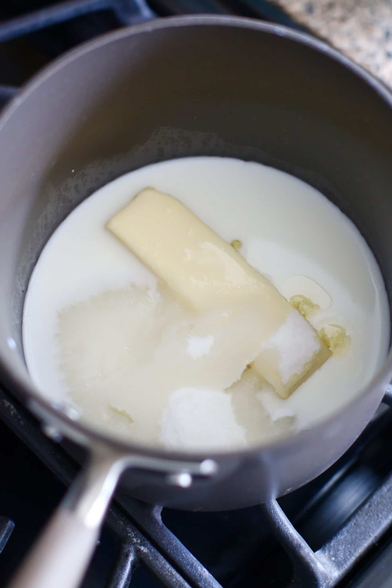 butter, sugar and milk shown in a pot on the stove.