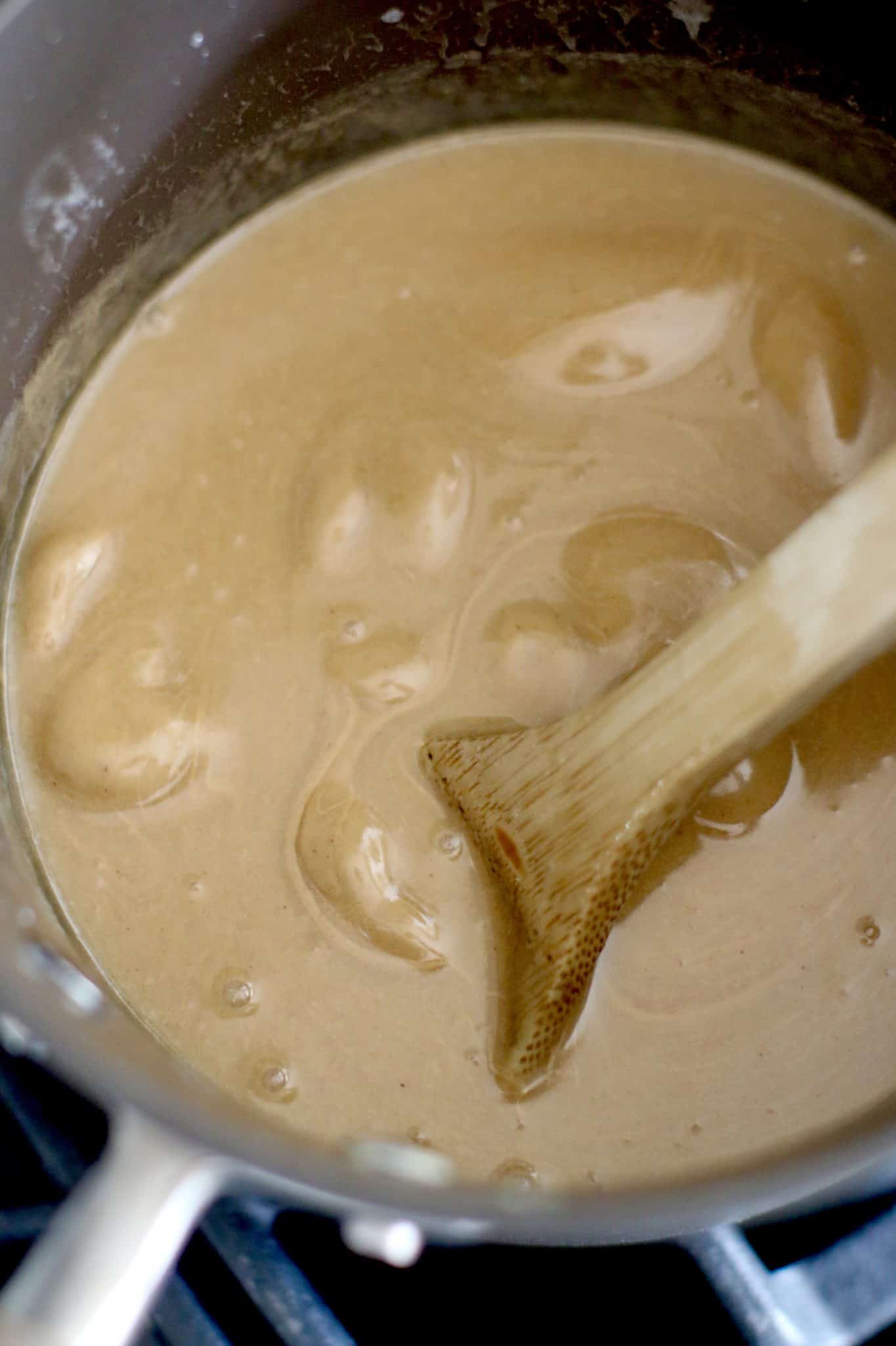 peanut butter added to boiling butter mixture in a pot.