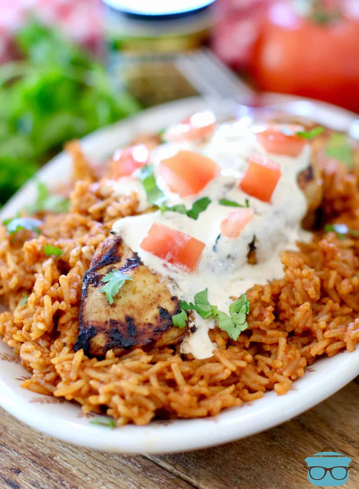 grilled lime chicken breast shown on Mexican rice on an oval plate. 
