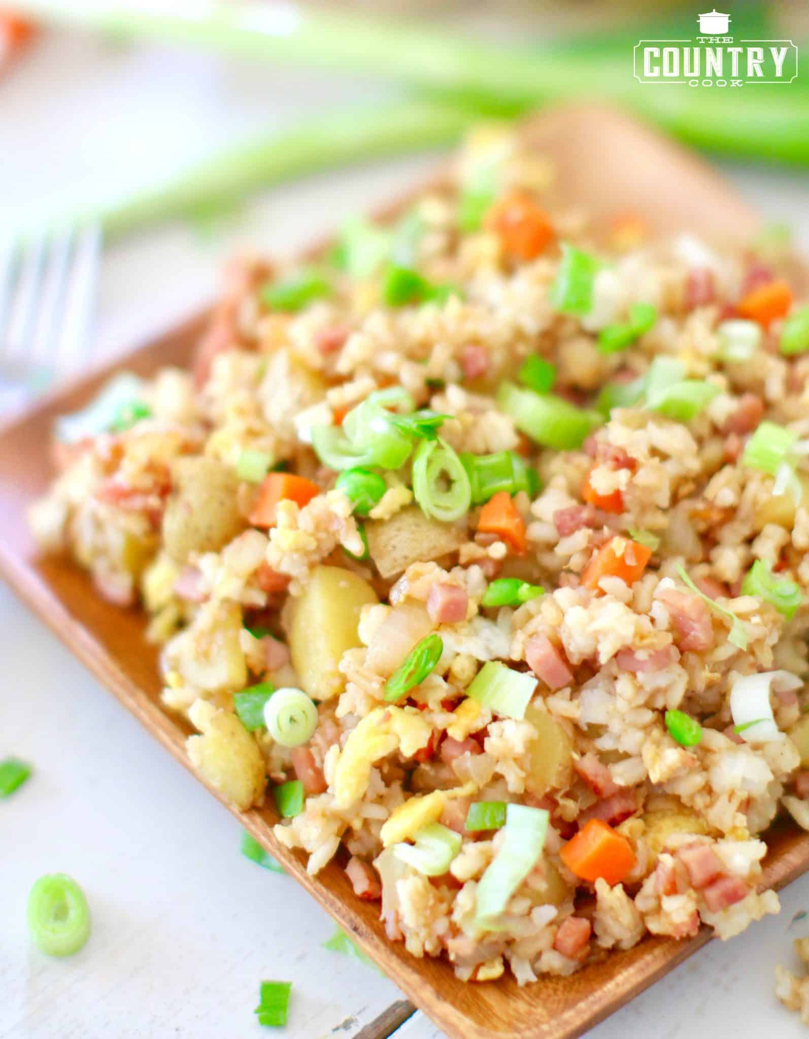 ham fried rice shown on a square bamboo plate. 