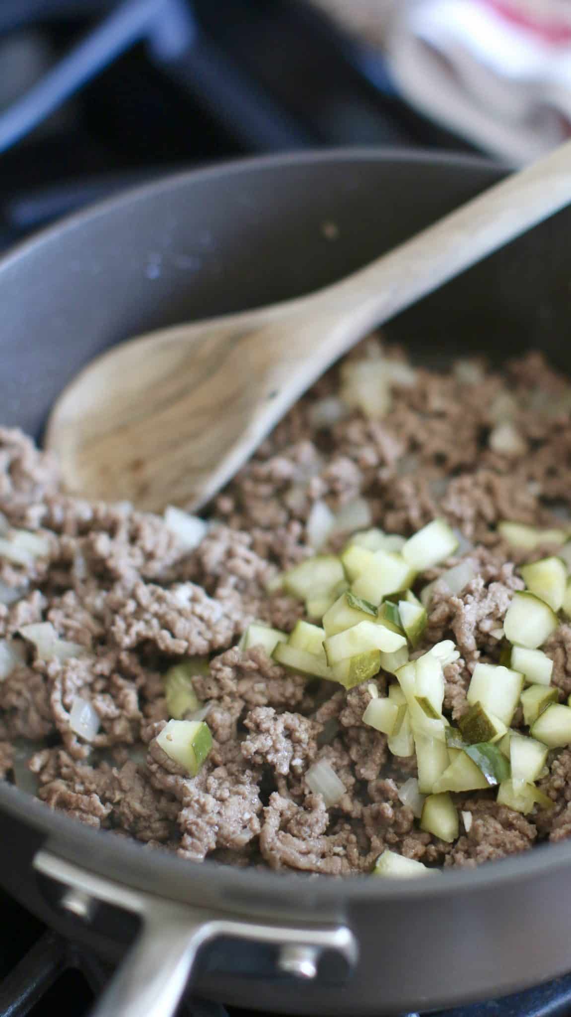 crumbled and cooked ground beef in a large skillet and topped with chopped pickles.