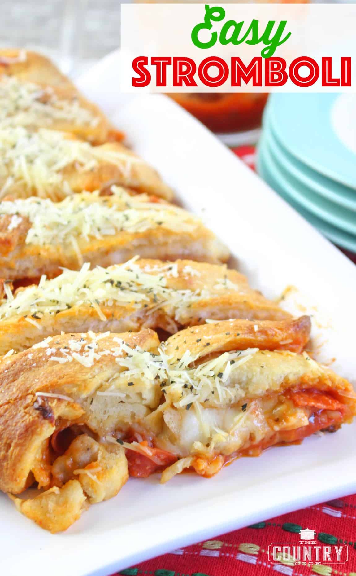 Easy Pepperoni and Sausage Stromboli shown sliced on a long white platter. 