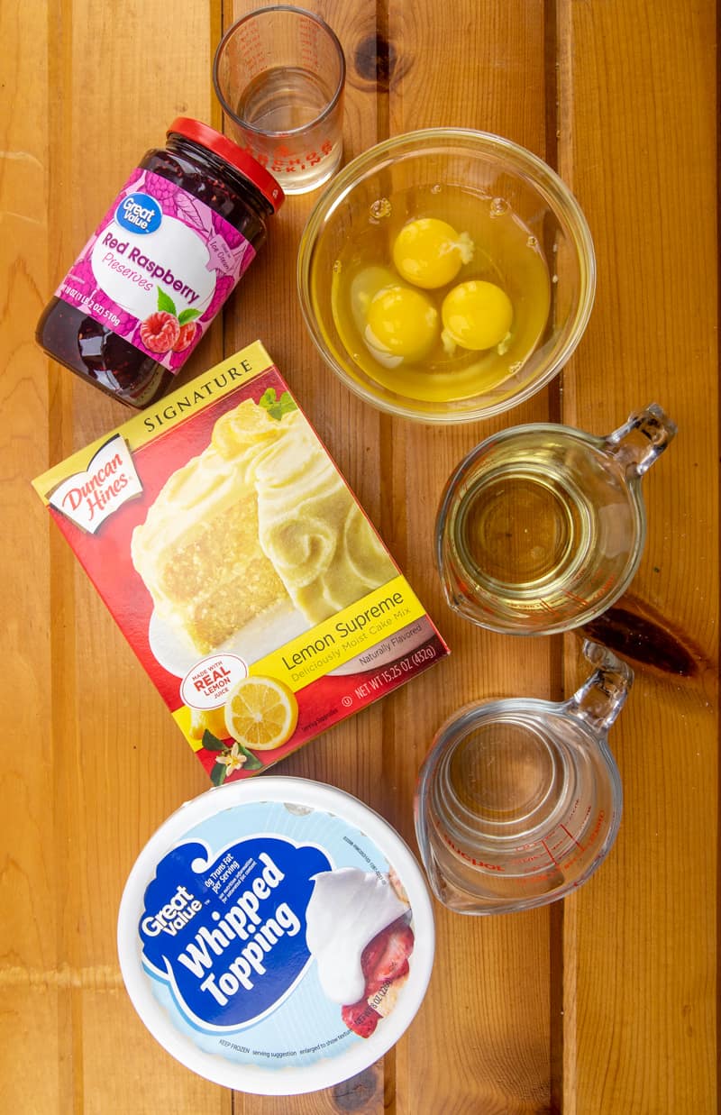lemon raspberry poke cake ingredients: lemon cake mix, eggs, oil, water, raspberry preserves, water, frozen whipped topping.