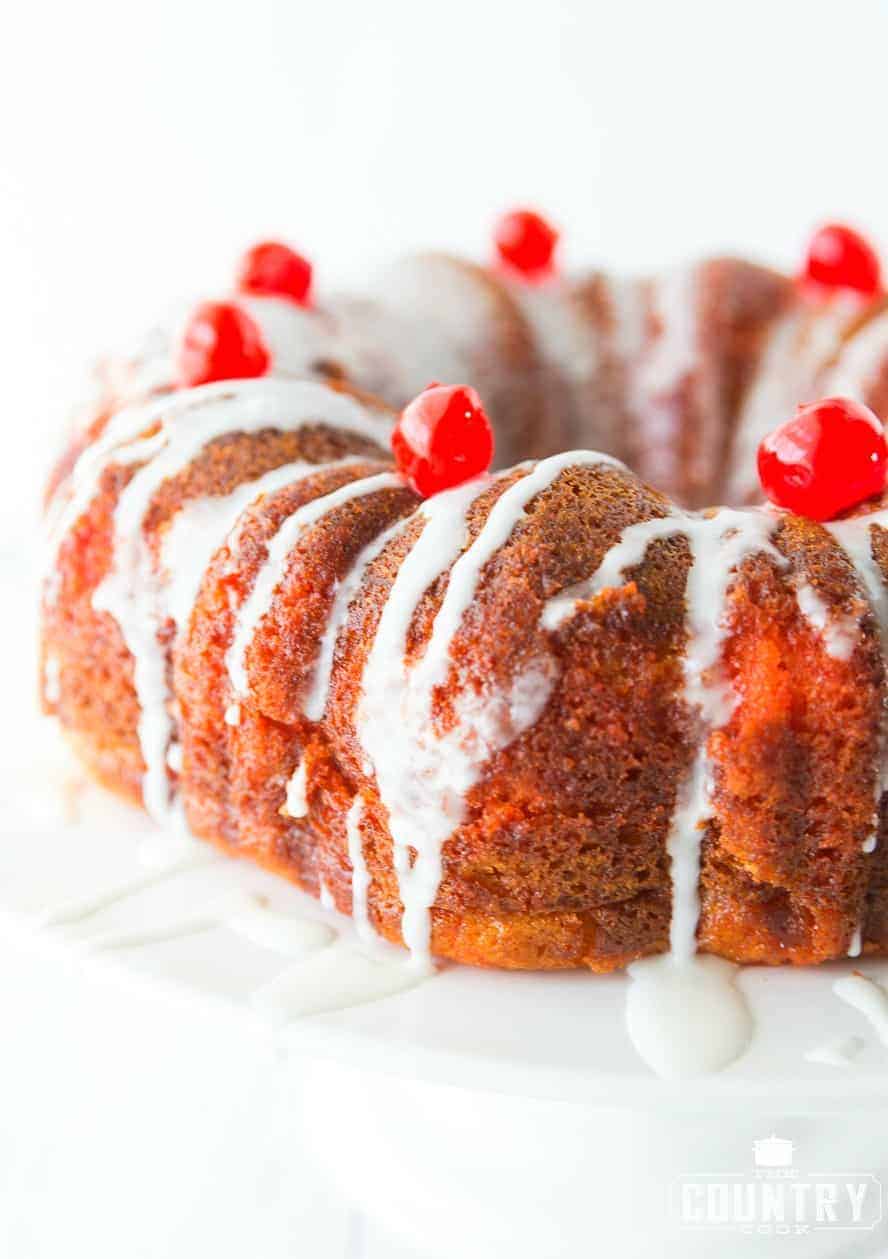 close up photo of Shirley temple bundt cake with maraschino cherries on top. 