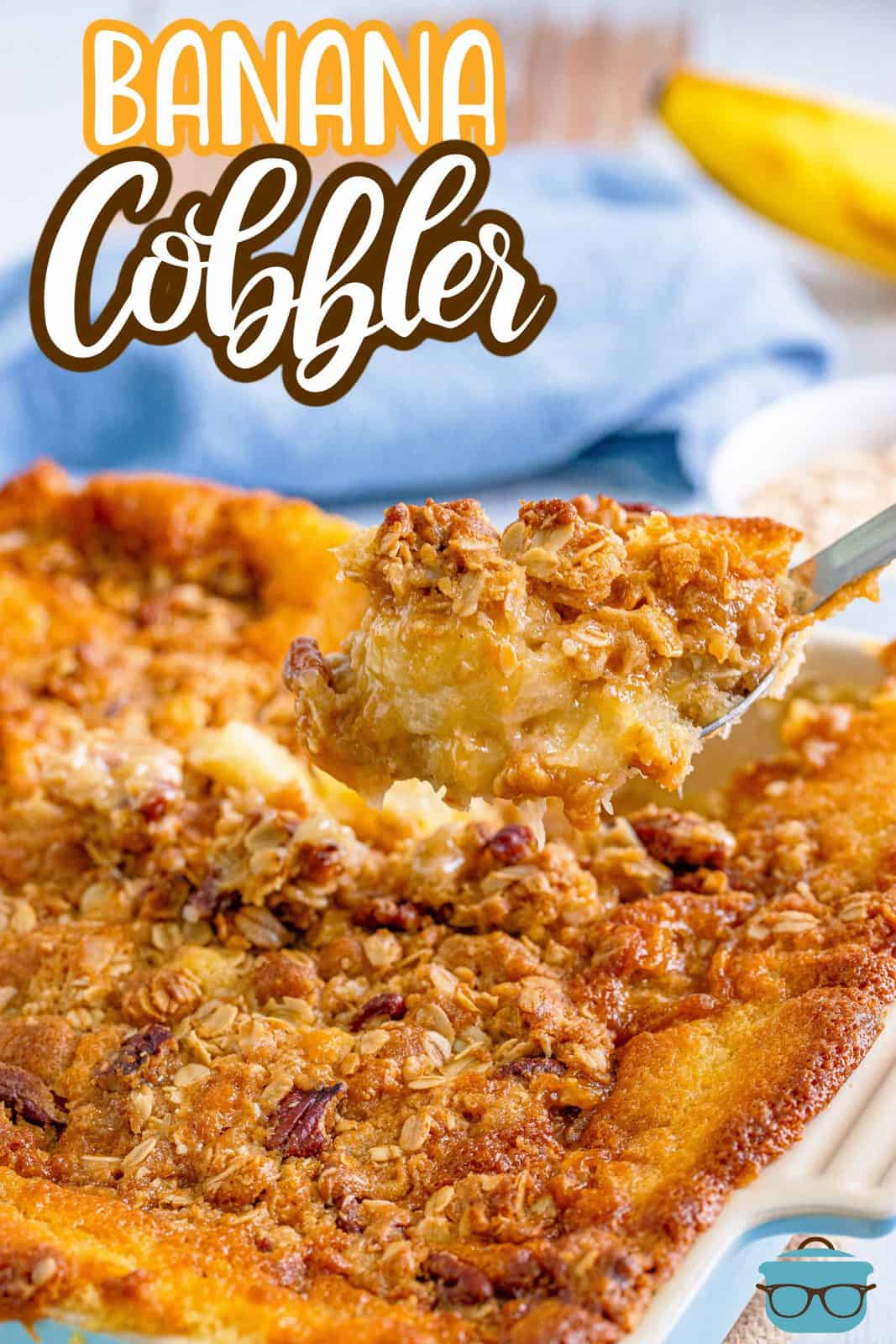 Banana Cobbler recipe from The Country Cook. Large spoon scooping out some of the cobbler from a baking dish.