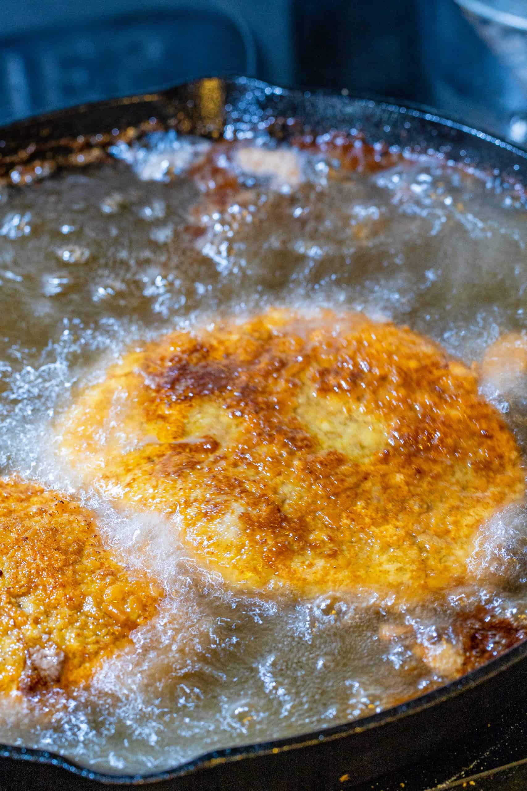 frying chicken fried steaks in vegetable oil in a cast iron pan.