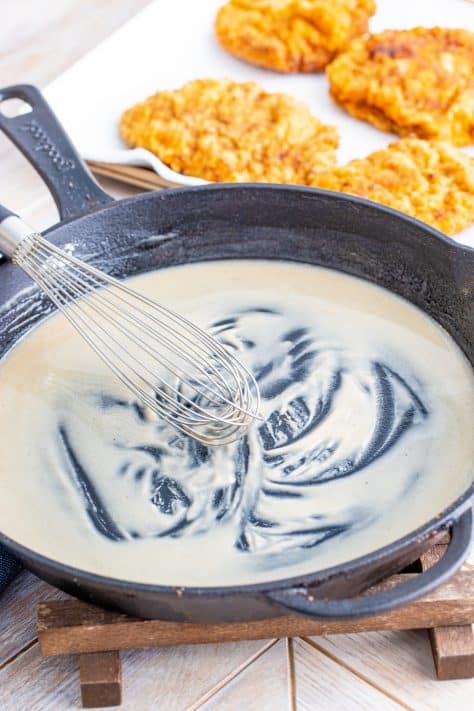 whisking flour and oil together in a cast iron pan