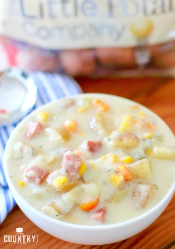 close up photo of a white bowl full of ham and potato corn chowder