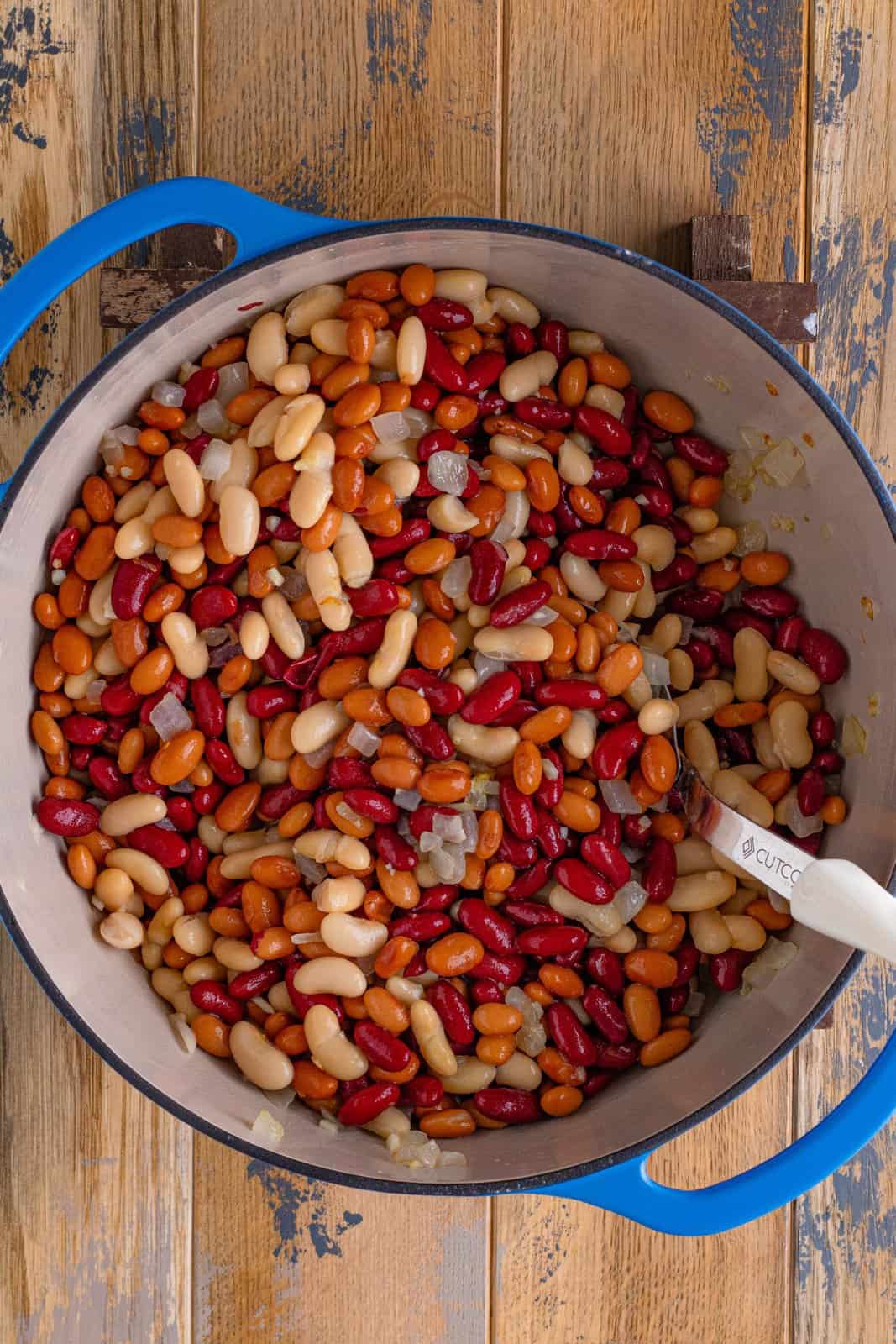 kidney beans, pinto beans and cannellini beans added to the large blue pot along with the onions. 