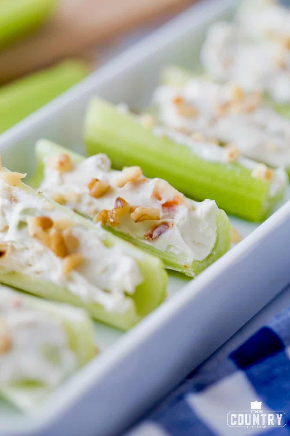 Celery stuffed with cream cheese and topped with chopped walnuts. Closeup photo.