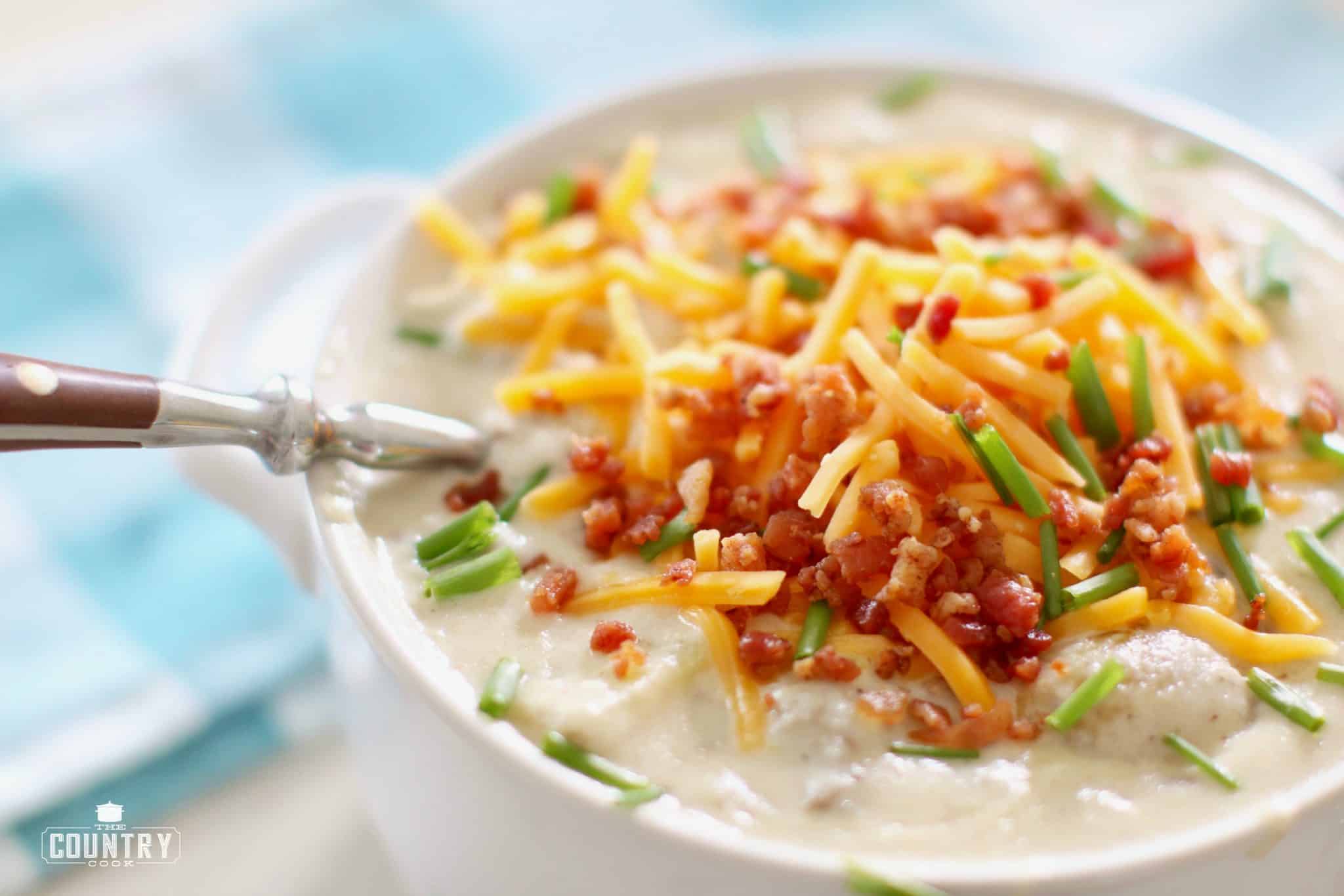 Bowlful of thick and creamy hamburger hash soup with a spoon inside. 