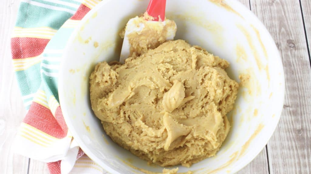 cake mix, peanut butter, butter and eggs stirred together in a white bowl
