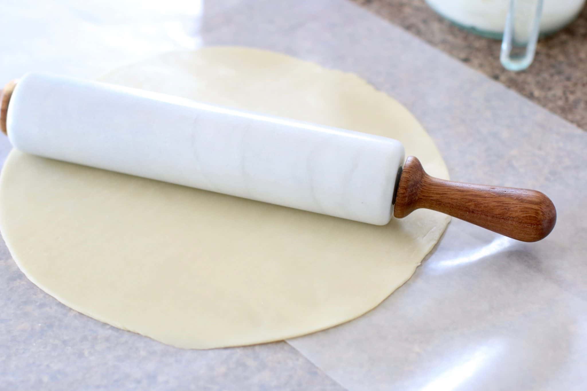 Pampered Chef Marble Rolling Pin on pie crust on wax paper.