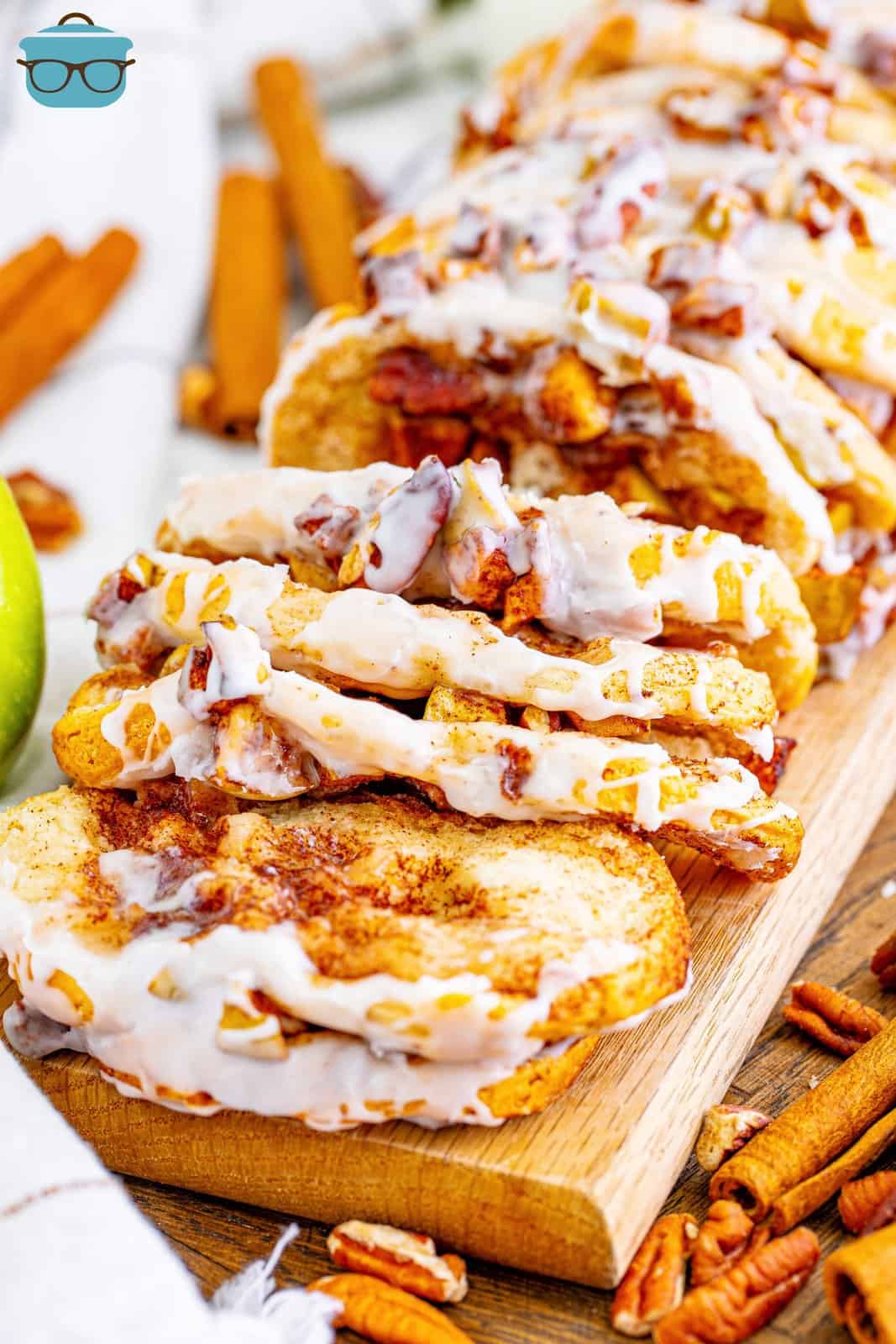 cinnamon apple pull apart bread shown in slices on a wooden board. 