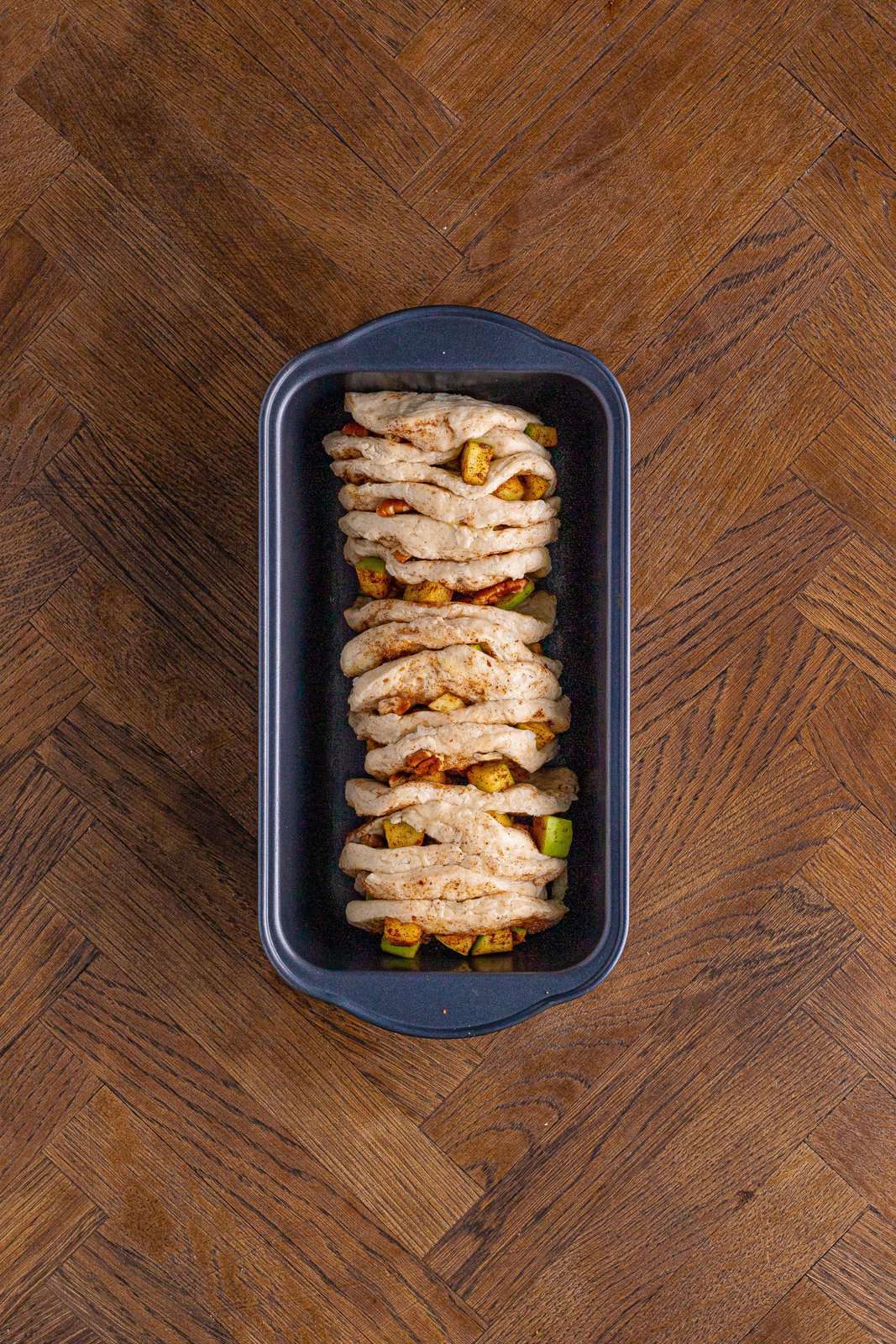 biscuit slices stacked into a loaf pan. 