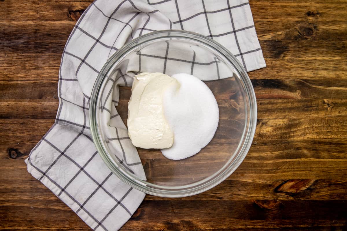 softened block of cream cheese and granulated sugar in the bottom of a medium glass bowl.