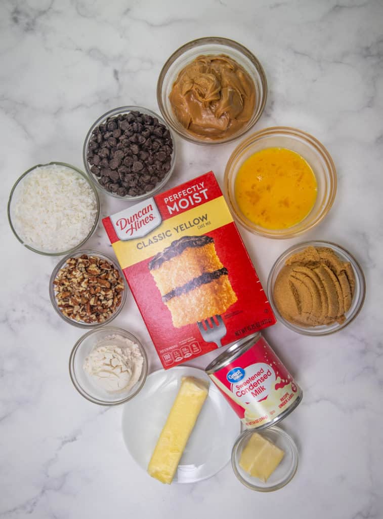 yellow cake mix, peanut butter, salted butter, eggs, semi-sweet chocolate chips, sweetened condensed milk, salted butter, sweetened flaked coconut, light brown sugar, all-purpose flour, chopped pecans