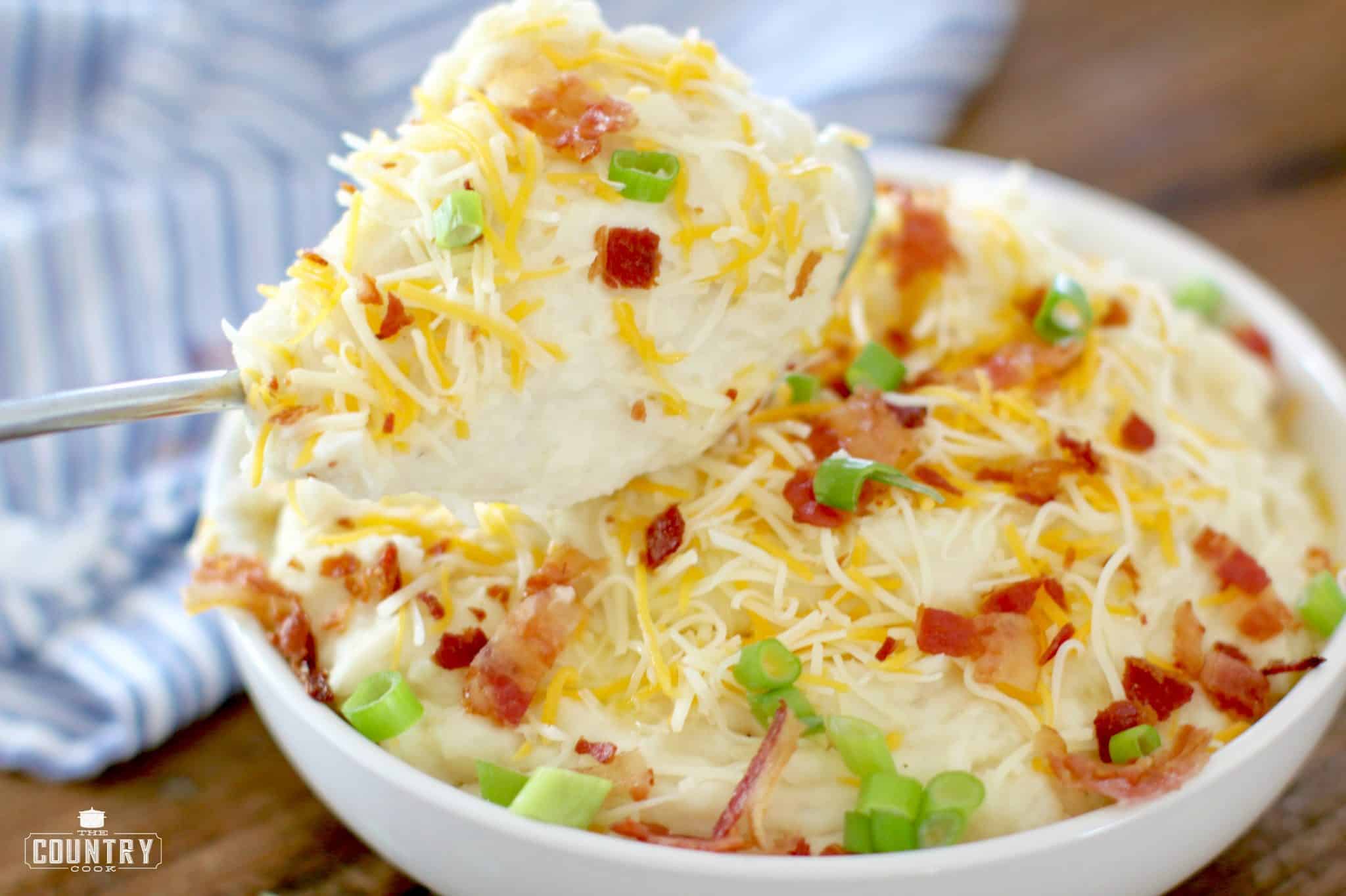 mashed potatoes topped with diced bacon, shredded cheddar cheese and sliced green onions.