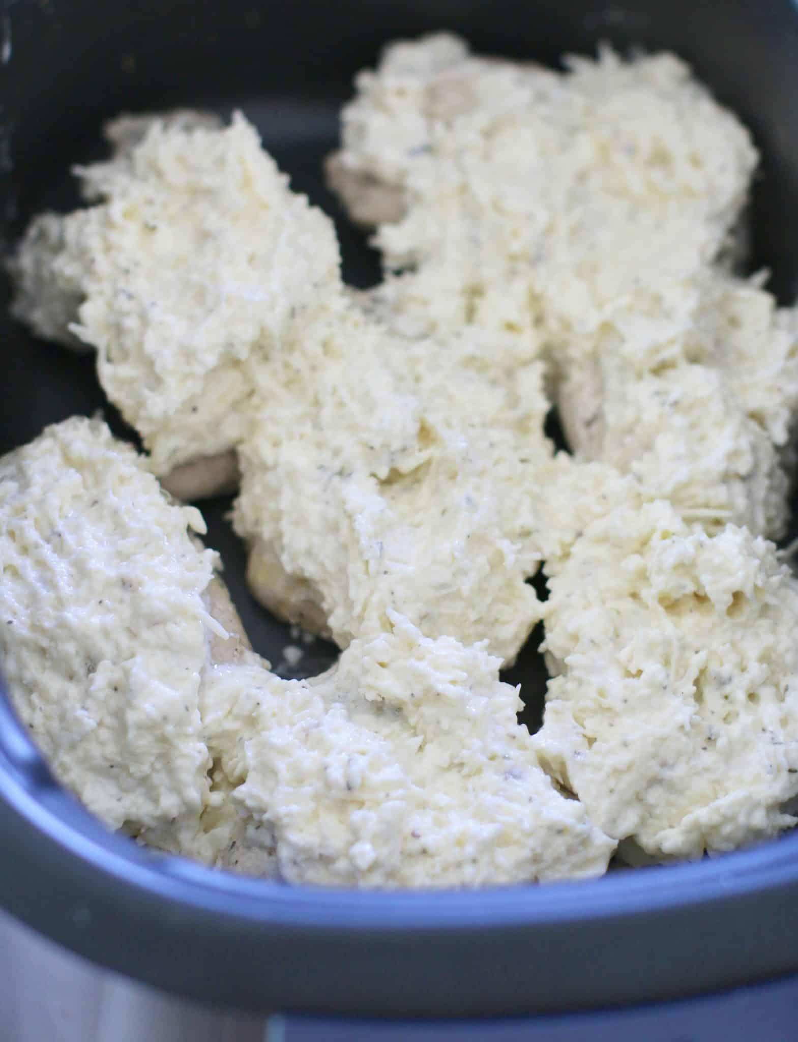 Garlic Parmesan coated chicken breasts in a slow cooker.