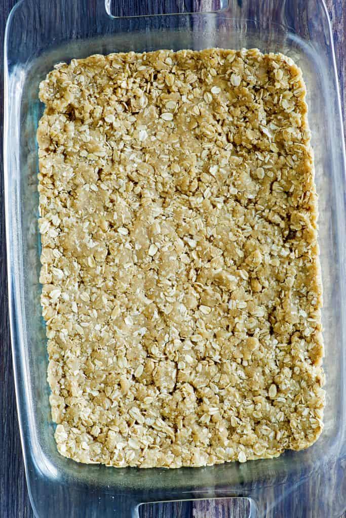 oatmeal bar mixture pressed into the bottom of a rectangular baking dish.