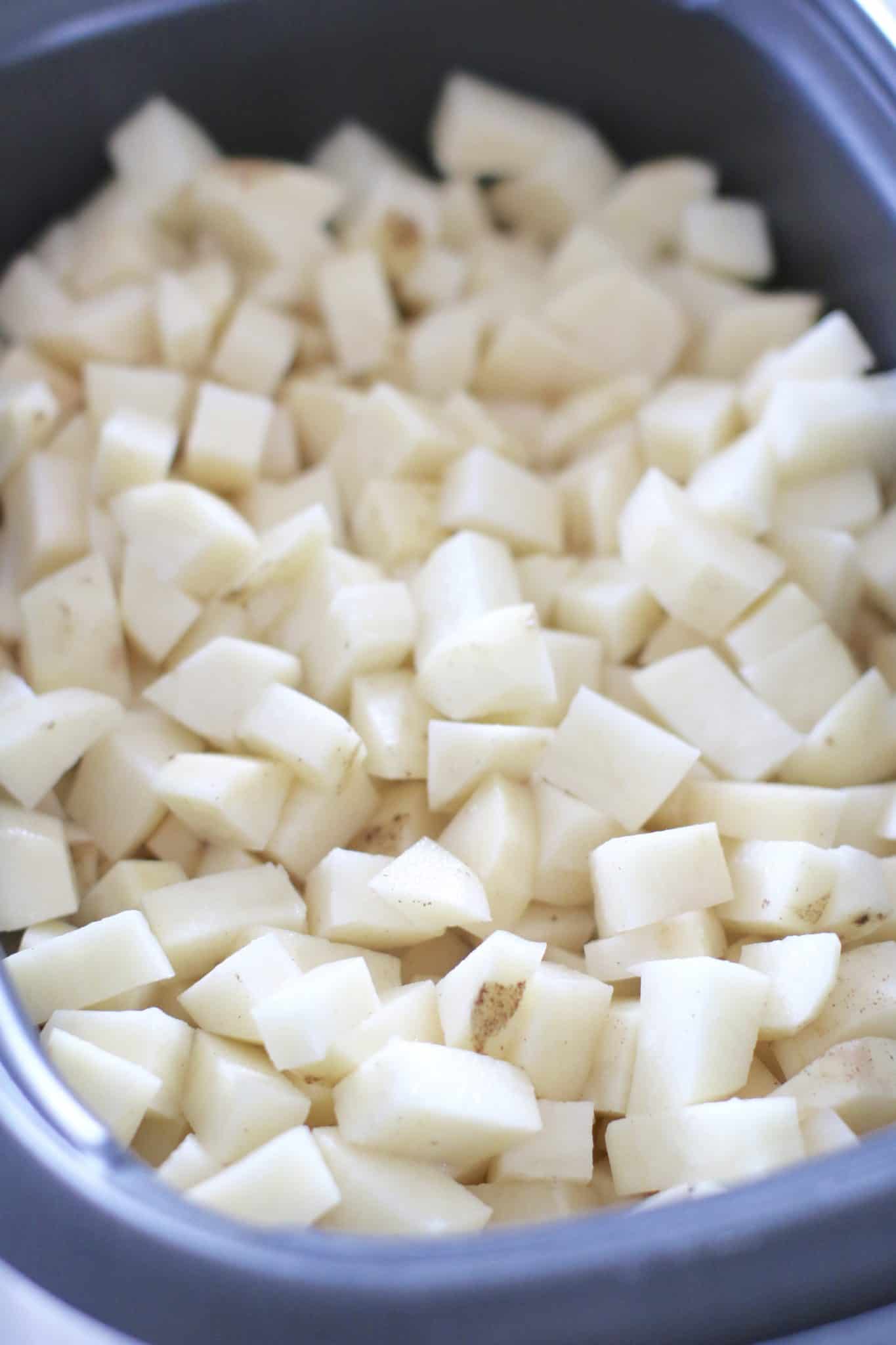 diced potatoes shown in an oval slow cooker.