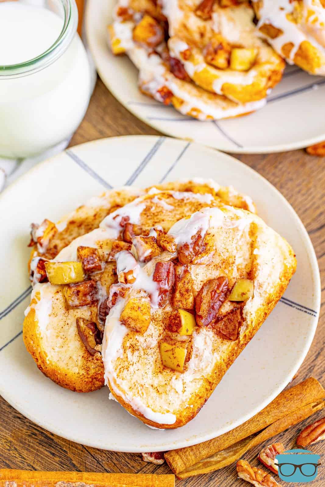 slices of cinnamon apple pull apart bread on a round white plate with a glass of milk in the background. 