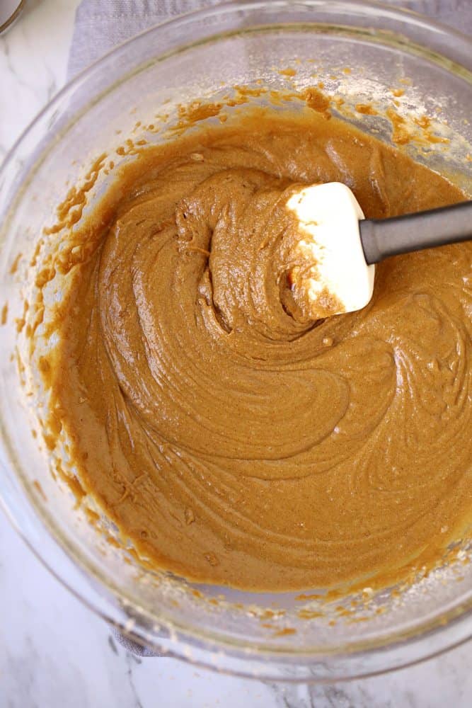flour, baking soda, sugar, cinnamon, ginger, butter, egg, milk, molasses mixed all together in a clear mixing bowl.