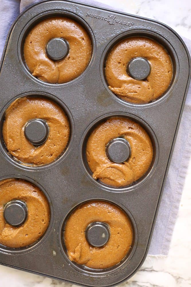 doughnut batter squeezed into donut pan spaces.