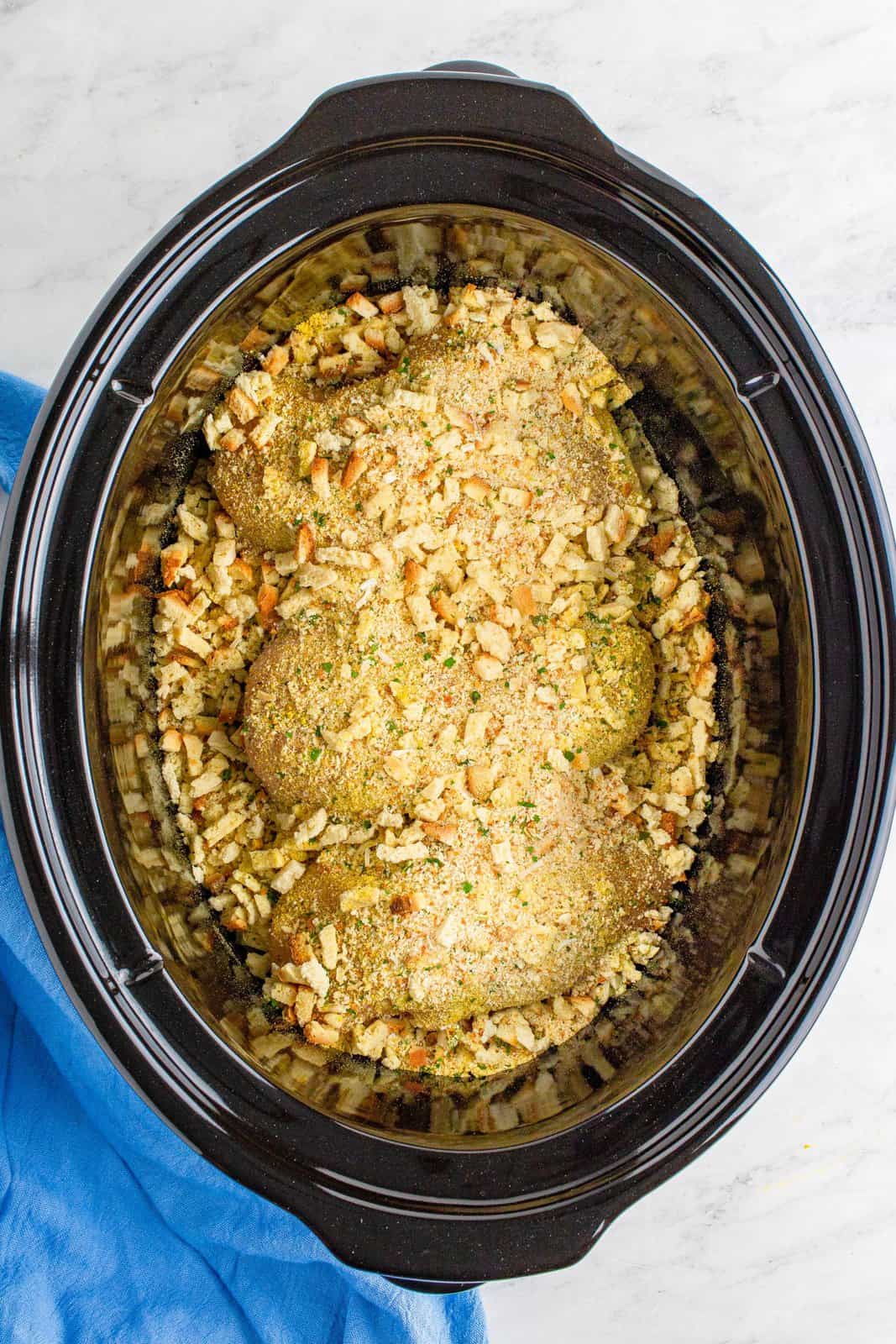 Stove Top stuffing sprinkled evenly over chicken breasts in slow cooker.