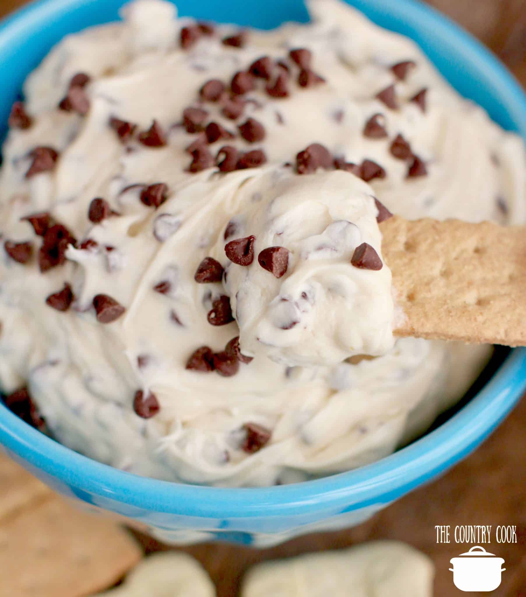 Cookie Dough Dip recipe in a blue bowl with a graham cracker.
