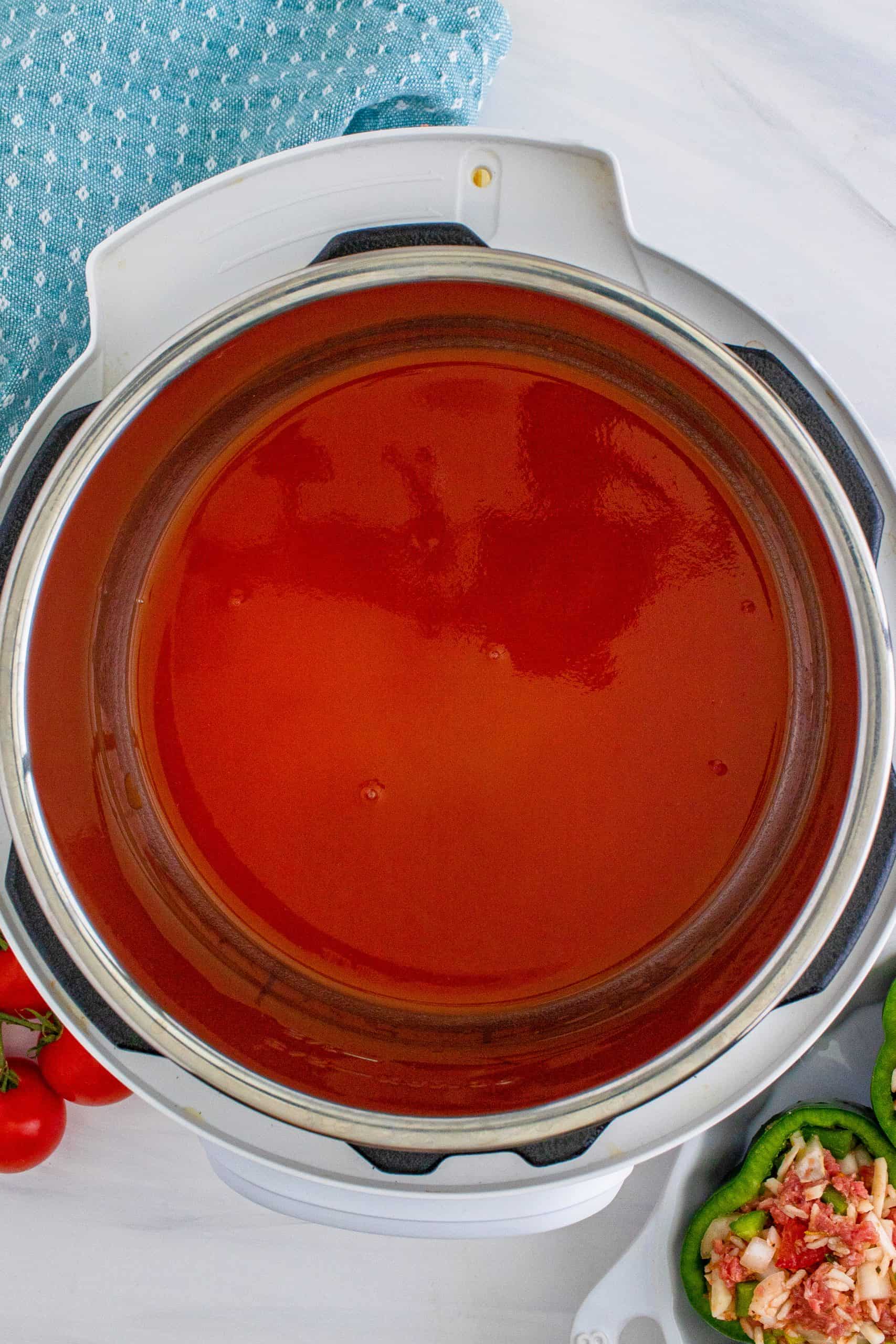 tomato sauce pored into the bottom of an instant pot.