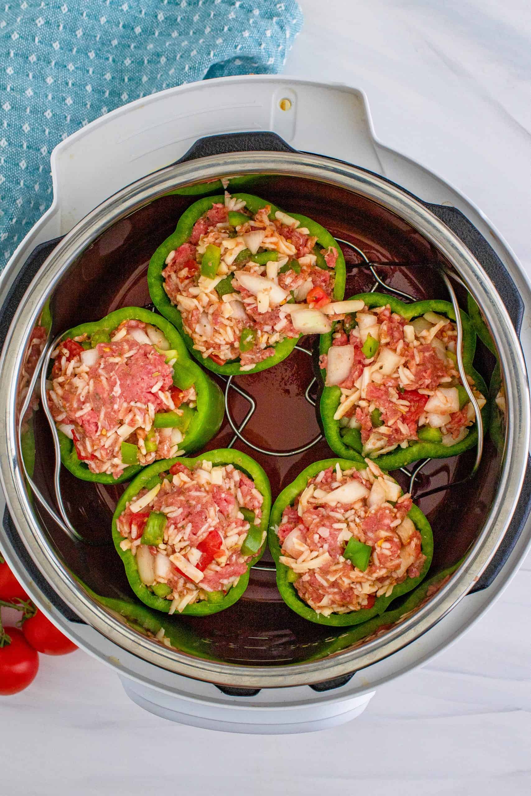 trivet holding 5 stuffed peppers placed inside the instant pot.