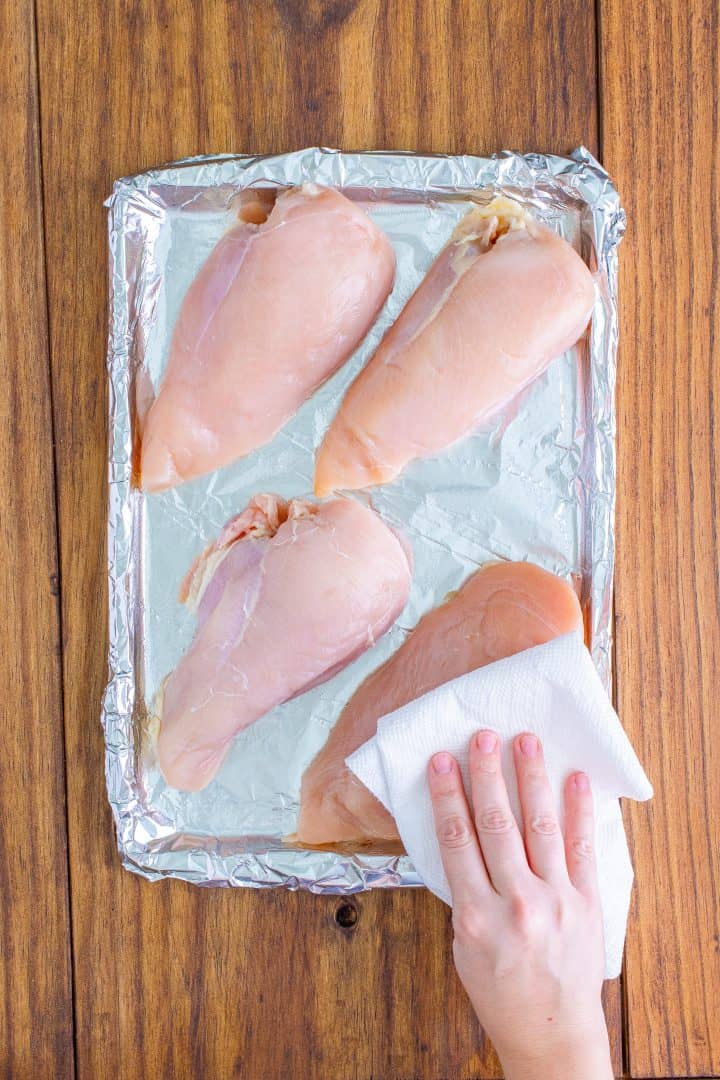 patting chicken breasts with a paper towel. 