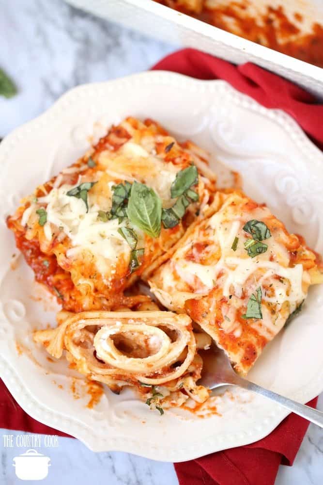 Easy Meatless Lasagna Rolls on a white plate topped with fresh basil and a fork.