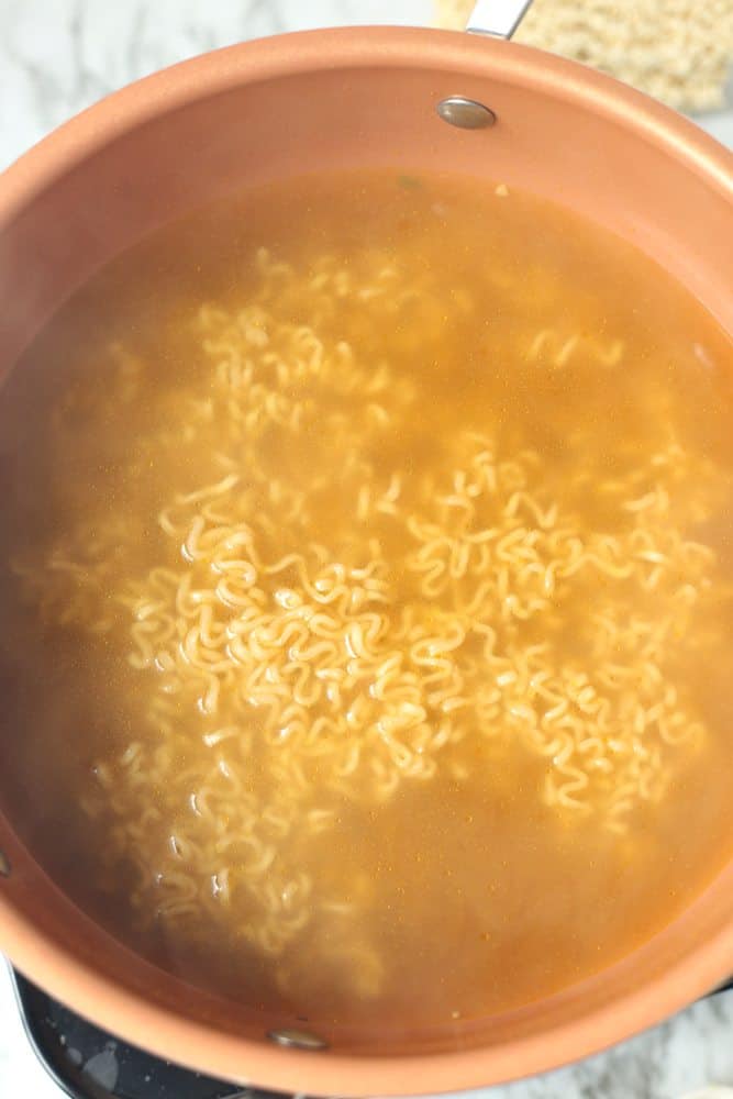 boiling ramen noodles in vegetable broth.